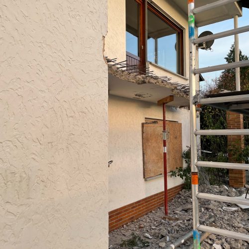 Ferienhaus Kellerwald Sanierungsarbeiten an einem Wohnhaus mit Gerüst und beschädigter Fassade Ferienhaus Edersee, Der alte Balkon muss dran glauben
