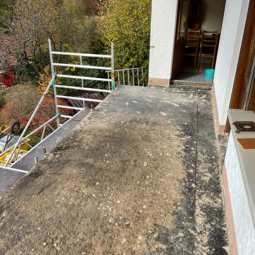 Ferienhaus Kellerwald Sanierungsbedürftiger Balkon mit sichtbaren Erdschichten und Blick auf die Bäume Ferienhaus Edersee