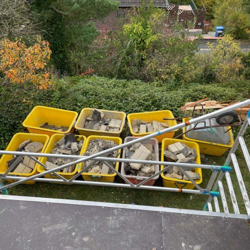 Ferienhaus Kellerwald Baustellenansicht mit gelben Containern voller Baumaterialien und Gerüst im Hintergrund Ferienhaus Edersee