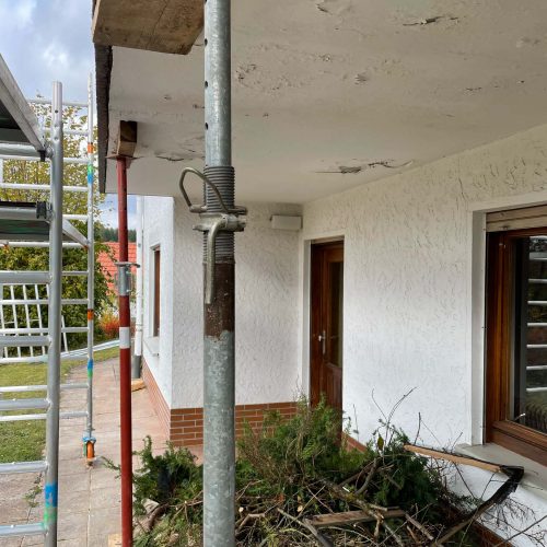 Ferienhaus Kellerwald Baustelle mit Gerüst, Stütze und Resten von Pflanzen vor einem Wohnhaus Ferienhaus Edersee