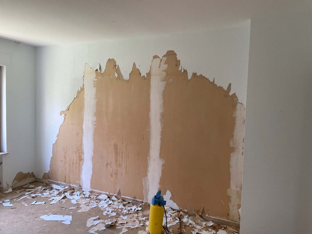 Ferienhaus Kellerwald Zimmer mit teilweise abgeblätterter Wandfarbe und Renovierungsabfällen auf dem Boden Ferienhaus Edersee