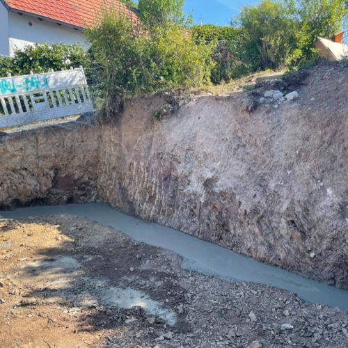 Ferienhaus Kellerwald Graben mit Wasseransammlung neben einem Haus, erodierte Erde und Vegetation sichtbar Ferienhaus Edersee