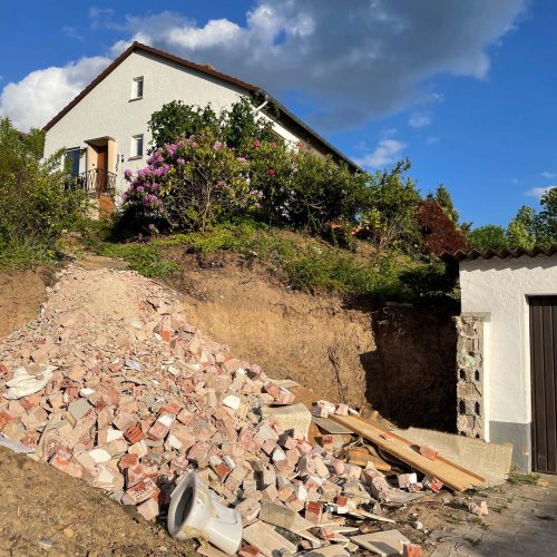 Ferienhaus Kellerwald Baustelle mit Schutt und einem kleinen Haus im Hintergrund unter blauem Himmel Ferienhaus Edersee