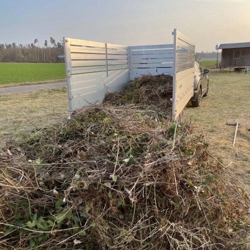 Ferienhaus Kellerwald Ein Fahrzeug mit einem Anhänger voller Gartenabfällen auf einem Feld Ferienhaus Edersee