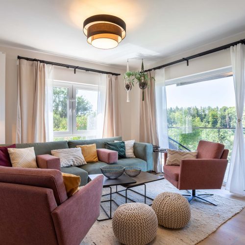 Helles Wohnzimmer mit gemütlicher Couch, modernen Sesseln und Blick auf die Natur, Ferienhaus Kellerwald Edersee