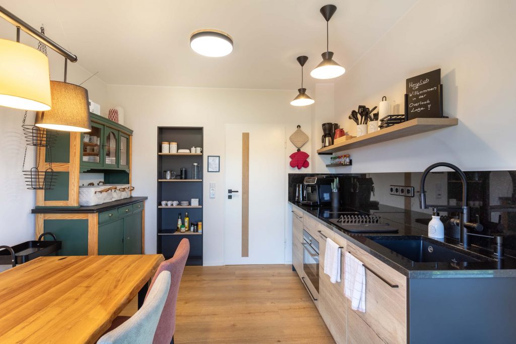 Vacation Home Kellerwald Modern kitchen with wooden tray, garden table, and colorful furniture Vacation Home Edersee