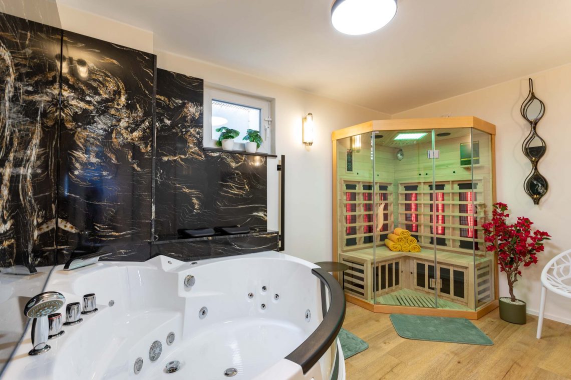 Ferienhaus Kellerwald Luxuriöser Wellnessbereich mit Whirlpool und Sauna in modernem Interieur. Wellness im Ferienhaus am Edersee im Kellerwald