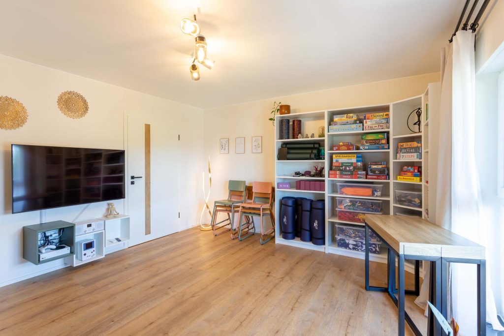 Vakantiehuis Kellerwald Lichte woonkamer met tv, planken en een groot raam vakantiehuis Edersee