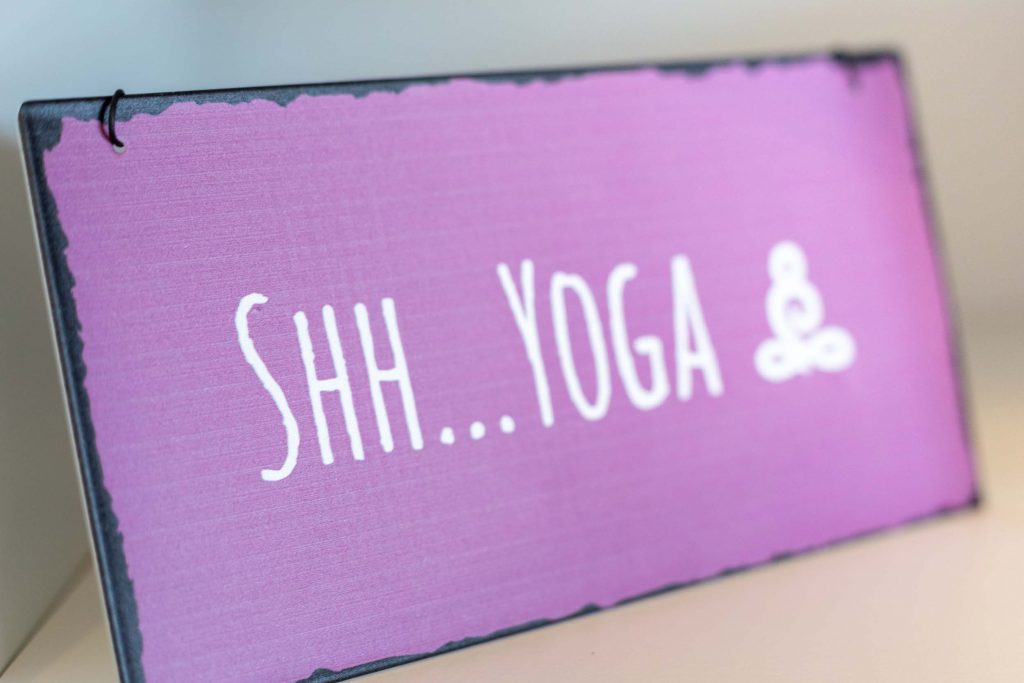 Vakantiehuis Kellerwald Paars bord met de tekst 'Shh... Yoga' en een meditatiesymbool, wellness in het vakantiehuis aan de Edersee in het Kellerwald