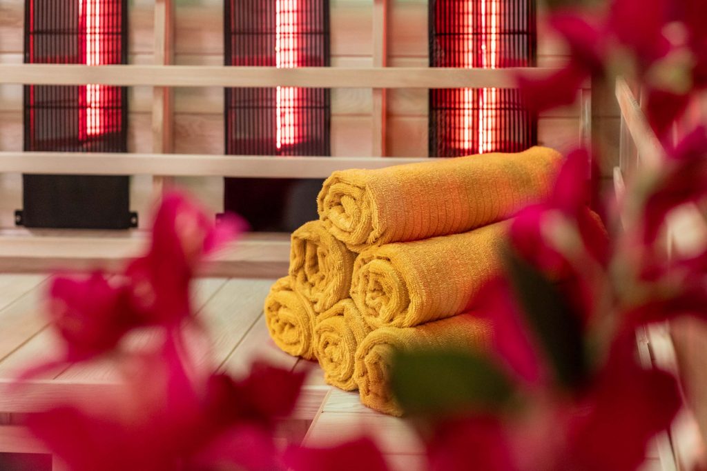 Vakantiehuis Kellerwald Geribbelde, gele handdoeken in een wellnessruimte met zachte rode verlichting Vakantiehuis Edersee, wellness in het vakantiehuis aan de Edersee in het Kellerwald