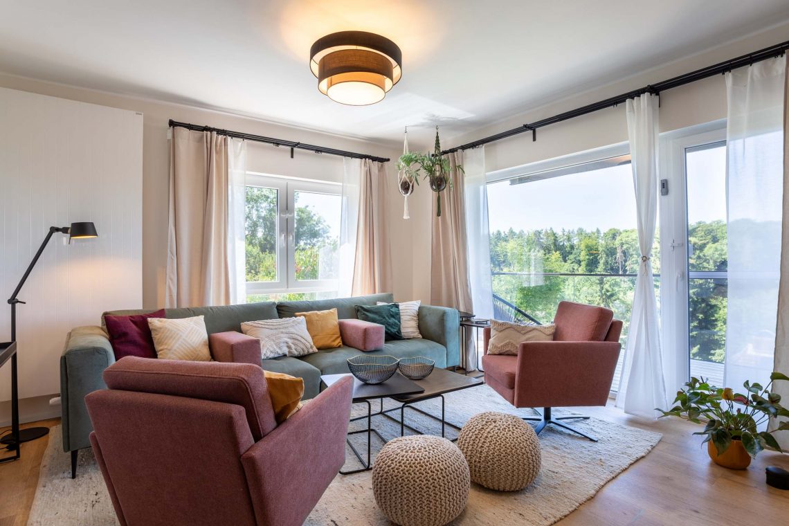 Helles Wohnzimmer mit gemütlicher Couch, modernen Sesseln und Blick auf die Natur, Ferienhaus Kellerwald Edersee