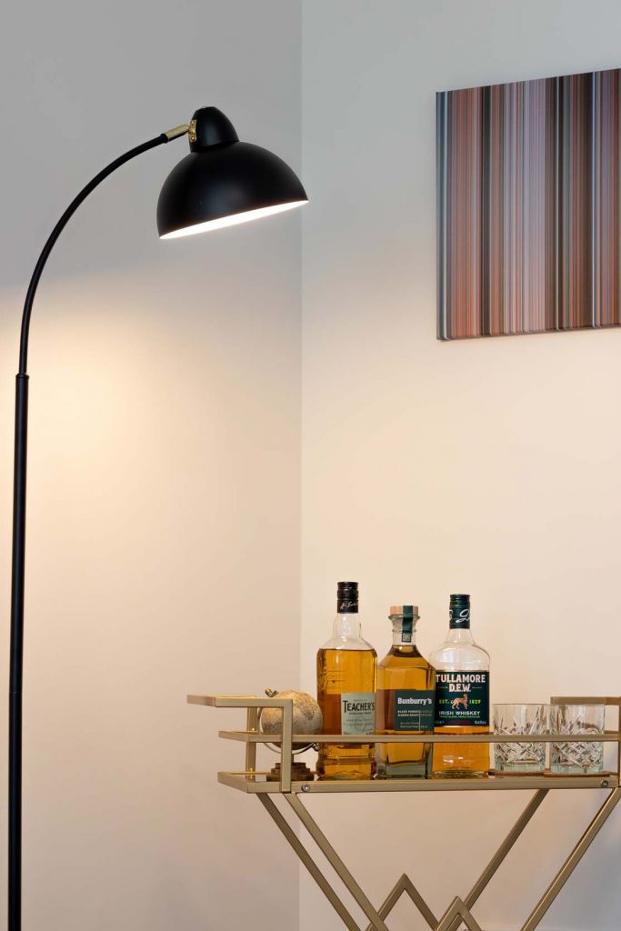 Modern floor lamp and bar cart with whiskey bottles and glasses, gallery,