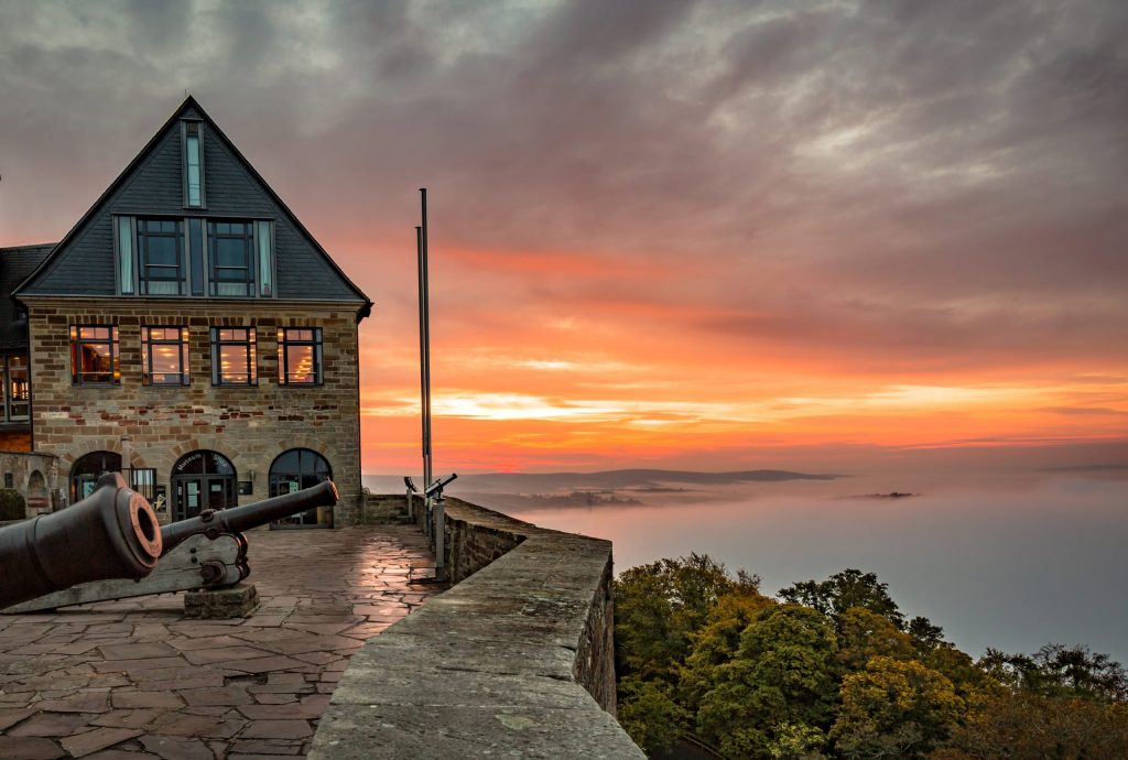 Ferienhaus Kellerwald Historisches Gebäude mit Aussicht auf den Sonnenuntergang über bewaldete Hügel Ferienhaus Edersee, Partnerschaft mit edersee.com