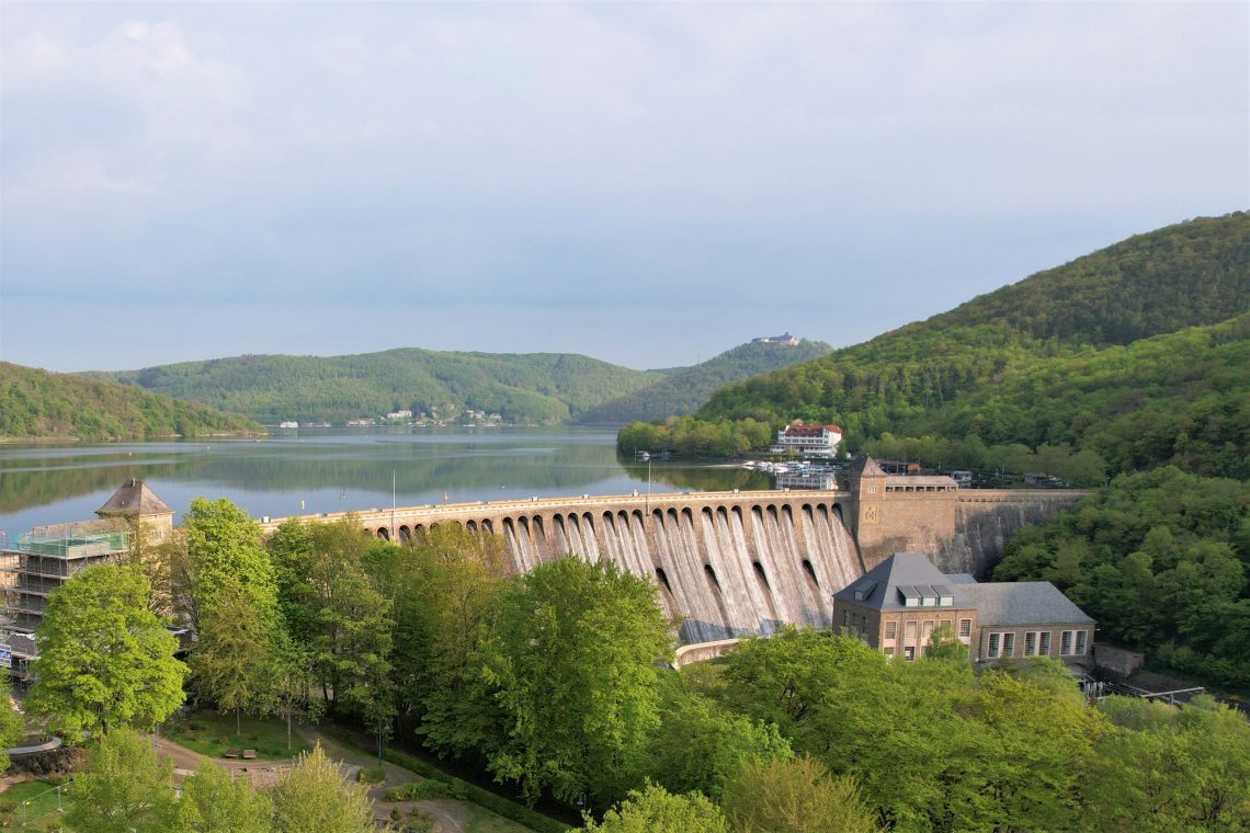 Ferienhaus Kellerwald Staumauer mit grüner Umgebung und Wasser im Hintergrund Ferienhaus Edersee, Partnerschaft mit edersee.com