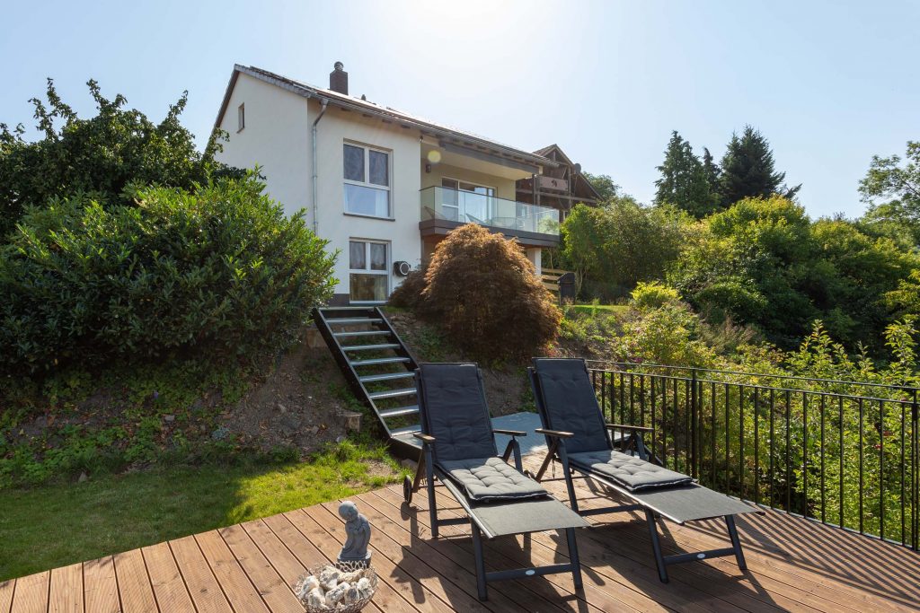 Ferienhaus Kellerwald Moderne Villa mit Terrasse, Liegestühlen und Garten im Hintergrund Ferienhaus Edersee. Das Haus