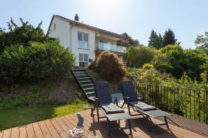 Ferienhaus Kellerwald Moderne Villa mit Terrasse, Liegestühlen und Garten im Hintergrund Ferienhaus Edersee. Das Haus