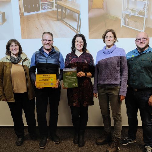 Fünf Menschen stehen nebeneinander auf einer Bühne, lächeln und halten Preise in einer Ausstellung oder Preisverleihung , Ferienhaus Edersee, Ferienhaus Kellerwald
