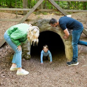 Kind krabbelt aus Holztunnel im Wald, Eltern beobachten , Ferienhaus Edersee, Ferienhaus Kellerwald