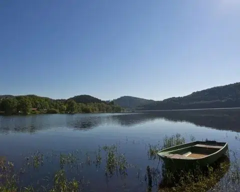 Rust aan het meer met een boot en beboste heuvels op de achtergrond, vakantiehuis Edersee, vakantiehuis Kellerwald