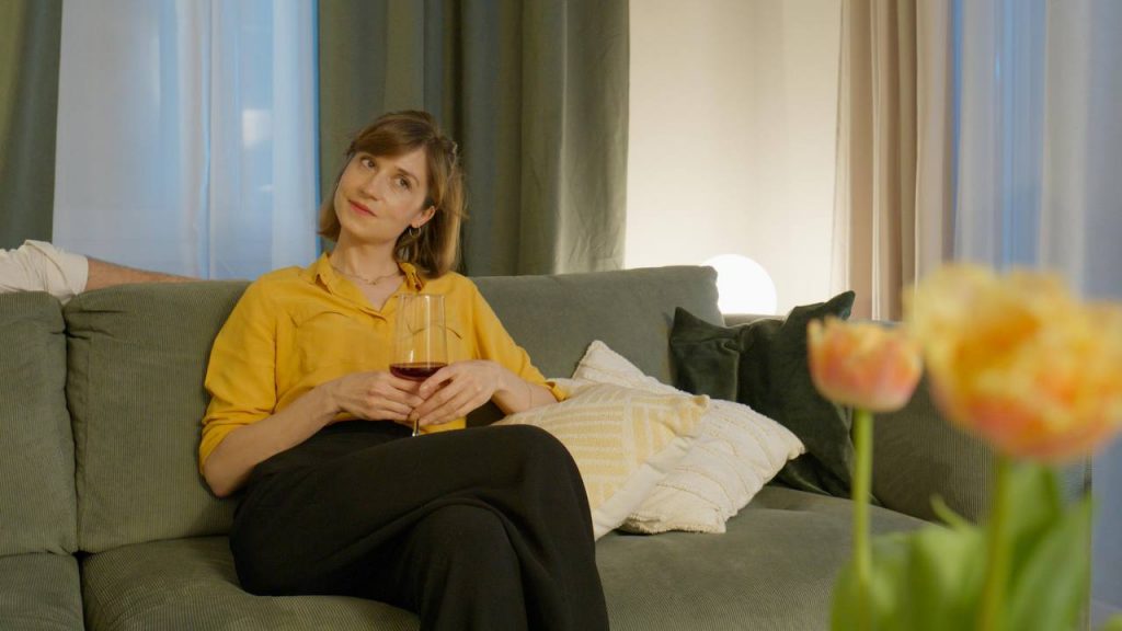 Woman with wine glass on sofa with tulips in the foreground, Edersee vacation home, Kellerwald vacation home