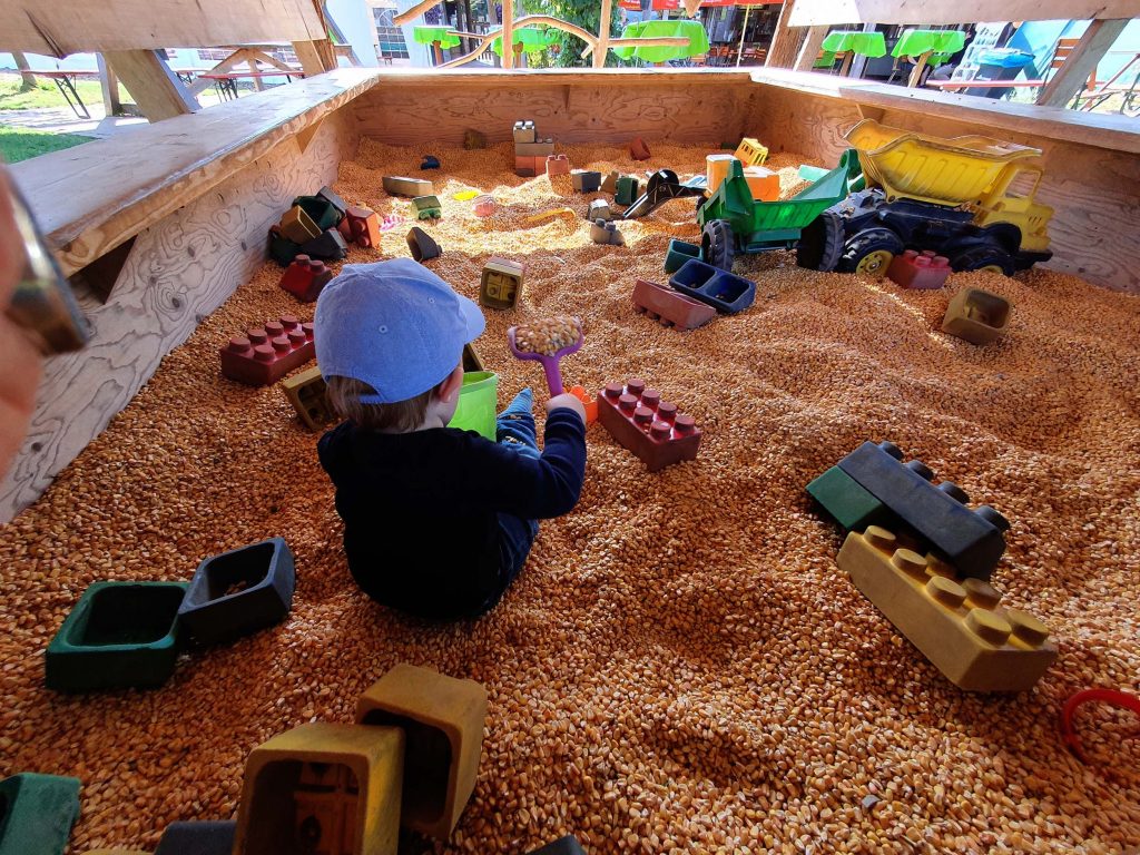 A child playing in corn kernels
