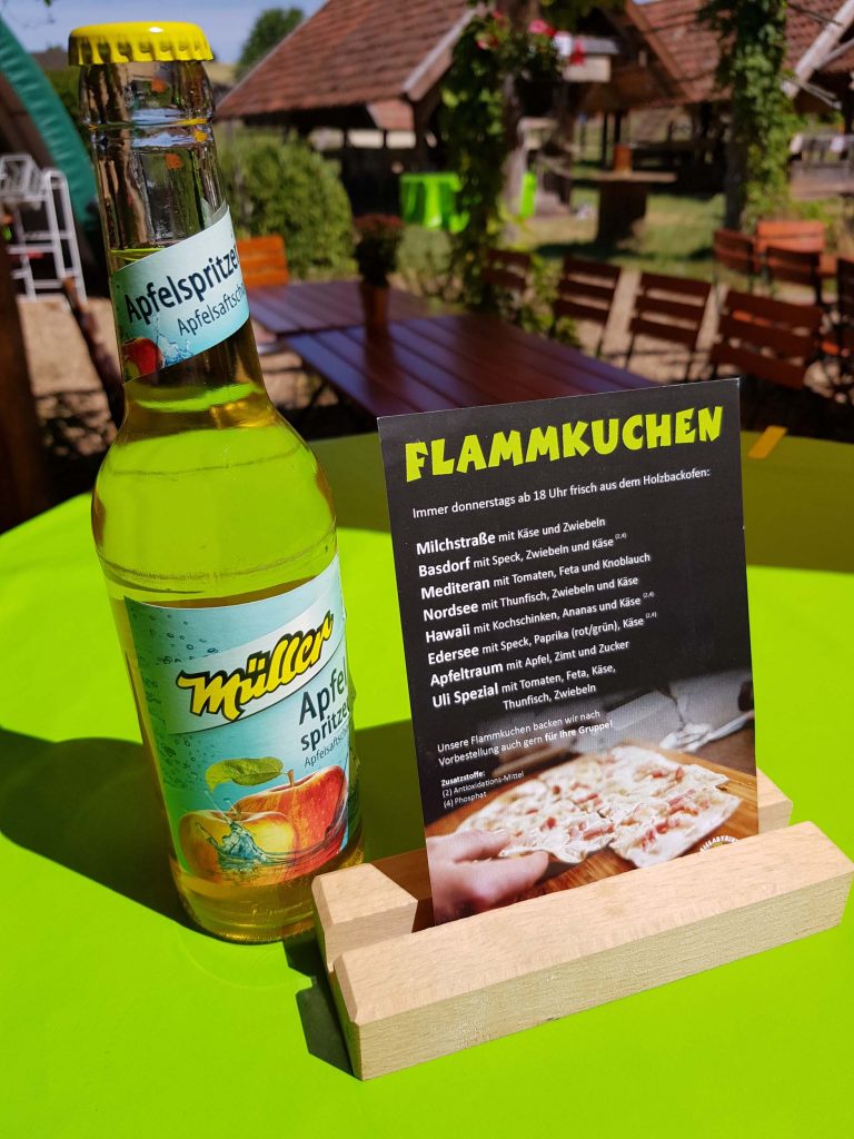 Tarte flambée offers and Müller apple spritzer on a green table, Vacation Home Edersee, Vacation Home Kellerwald