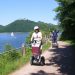 People ride Segways along a lake with hills in the background, vacation home Edersee, vacation home Kellerwald