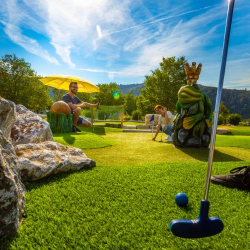 Adventure Golf Edersee, gezin speelt minigolf op zonnige baan in schilderachtig landschap, Vakantiehuis Edersee, Vakantiehuis Kellerwald