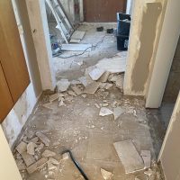 Ferienhaus Kellerwald Rohbau eines Flurs mit zerbrochenen Fliesen und Baustellenmaterial Ferienhaus Edersee