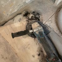 Ferienhaus Kellerwald Boden Schleifmaschine auf einem Baustellenboden mit Staub und Schmutz Ferienhaus Edersee