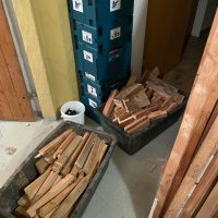 Ferienhaus Kellerwald Stapel von Holzlatten in Kisten neben Werkzeugkoffer in einem Raum Ferienhaus Edersee, Der Abriss geht weiter